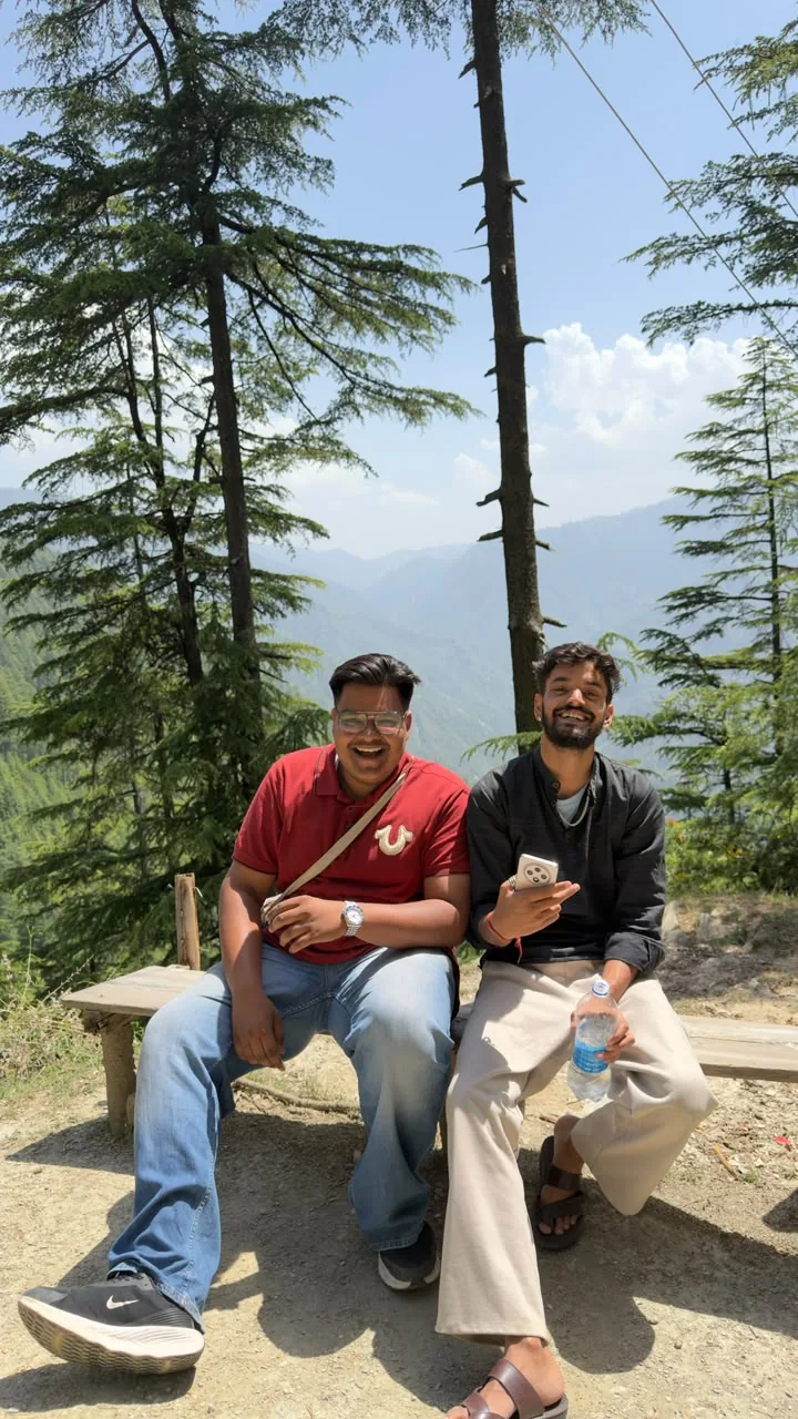 Founder Surya and co-founder Harshit Goyal of Markandey Holidays together on a mountain bench among deodar trees